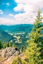 An young man sitting at the end of a rock, looking at the magnificent mountain aria view