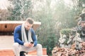 Young man sitting in the fountain of a park looking at his cell phone Royalty Free Stock Photo