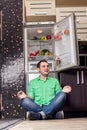 Young Man Sitting In Front Of Fridge Royalty Free Stock Photo