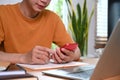 Man sitting in front of laptop computer and using smart phone in living room. Royalty Free Stock Photo