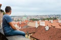 A young man sitting in front of Prague tiled roofs. Czech Royalty Free Stock Photo