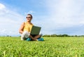 Young man sitting on the grass and working with laptop Royalty Free Stock Photo