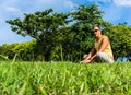 Young man sitting on the grass and working with laptop Royalty Free Stock Photo