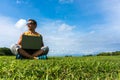 Young man sitting on the grass and working with laptop Royalty Free Stock Photo