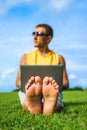 Young man sitting on the grass and working with laptop Royalty Free Stock Photo