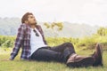 Young man sitting on green grass thinking Royalty Free Stock Photo