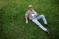 Young man sitting on green grass and working on laptop outdoors Royalty Free Stock Photo