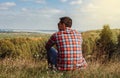 Young man sitting on a hill enjoying scenery. Concept of travel and freedom Royalty Free Stock Photo