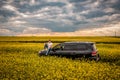 Young man sitting on the hood of a black car Royalty Free Stock Photo