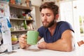 Young Man Sitting At Kitchen Table Drinking Coffee Royalty Free Stock Photo