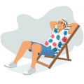 Young man sitting in lounge deck chair at the beach and relaxing Royalty Free Stock Photo