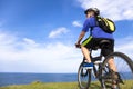 Young man sitting on a mountain bike and looking the ocean Royalty Free Stock Photo