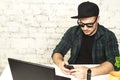 Young man sitting in office with a cup of coffee and vaping