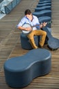 Young man sitting outside, playing music Royalty Free Stock Photo