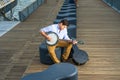 Young man sitting outside, playing music Royalty Free Stock Photo