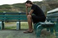 Sad depressed man sitting on a park bench Royalty Free Stock Photo