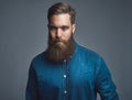 Young man sitting pensively against a gray background Royalty Free Stock Photo