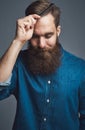 Young man sitting pensively against a gray background Royalty Free Stock Photo