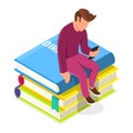 Young man sitting on pile of books and looking to smartphone. Man using media book library. Royalty Free Stock Photo