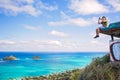 Young man sitting on pillbox over looking Lanikai taking a cell