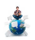 Young man sitting on a planet with a tablet