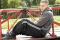 Young Man Sitting In Playground Royalty Free Stock Photo