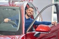 Young man almost sitting in red car and closing front door. Royalty Free Stock Photo