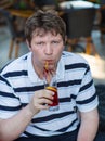 Young man sitting in restaurant and drinking cocktail Royalty Free Stock Photo