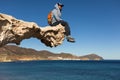 Young man sitting on sculpted rock structure, Los Escullos, Spain Royalty Free Stock Photo