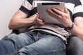 young man sitting on sofa using digital tablet. Home work or study, freelance, online shopping, distance education Royalty Free Stock Photo