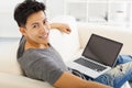 Young Man sitting in sofa and using laptop