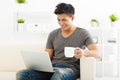 Young Man sitting in sofa and using laptop Royalty Free Stock Photo