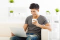 Young Man sitting in sofa and using laptop Royalty Free Stock Photo