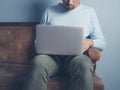 Young man sitting on sofa using laptop Royalty Free Stock Photo