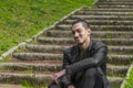 Young man sitting on the stairs with a happy face Royalty Free Stock Photo