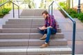 Young man sitting on stairs and using tablet PC Royalty Free Stock Photo