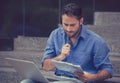 Young man sitting on steps outside corporate city building using a laptop Royalty Free Stock Photo