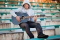 Young man sitting on steps playing guitar and singing Royalty Free Stock Photo