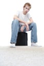 Young man sitting on a subwoofer