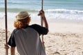 Young man sitting on the swing on the beach, feeling so sad ,alone,lonely Royalty Free Stock Photo