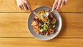 Lunch Time. Guy sitting at table eating salmon salad top view close-up Royalty Free Stock Photo