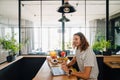 Young man sitting by table while working on laptop in office kitchen Royalty Free Stock Photo