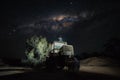 Young Man Sitting on Tractor Roof at Night Watching the Milkyway. Traveler Concept