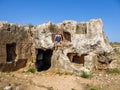 Cyprus - Young man sitting on a rock house