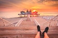 Young man sitting on wooden pier enjoying sunrise at Seebrucke Sellin, Baltic Sea, Germany Royalty Free Stock Photo