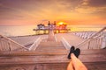 Young man sitting on wooden pier enjoying sunrise at Seebrucke Sellin, Baltic Sea, Germany Royalty Free Stock Photo