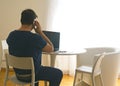 Young man sitting and working on laptop at home speaking to the mobile. Working father concept. teleworking concept Royalty Free Stock Photo