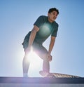 Young man, skateboard and freedom on blue sky lens flare at urban skate park, city and relaxing summer for training Royalty Free Stock Photo