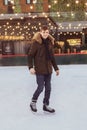 A young man skating on a skating rink, looks at the camera and smiles Royalty Free Stock Photo