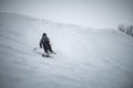 Young man skiing down a snowy mountain slope